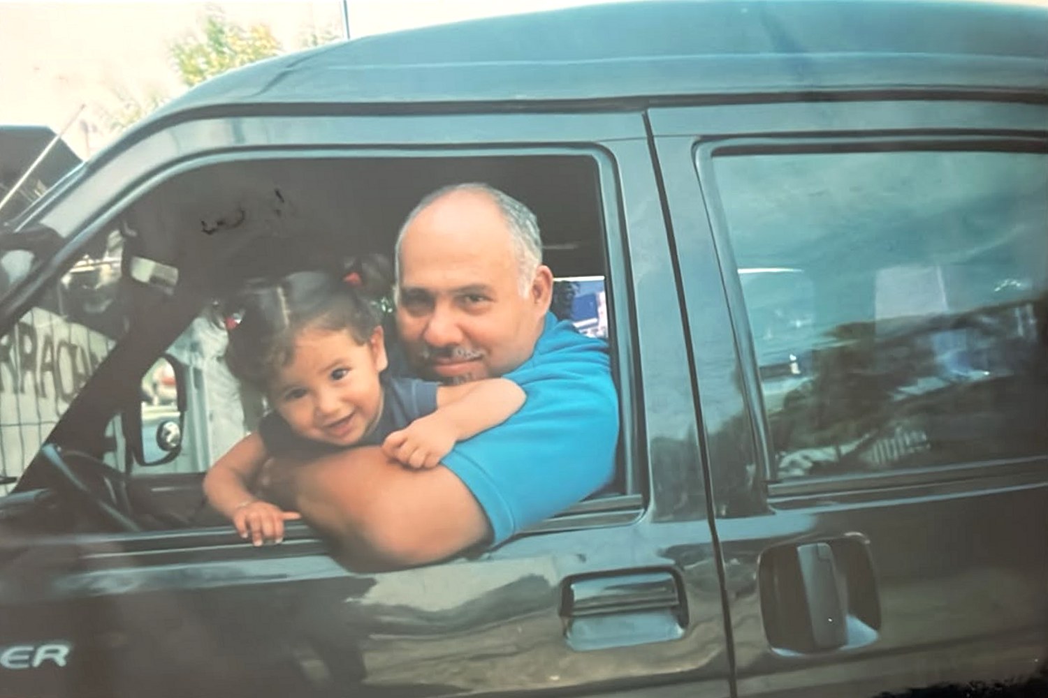 Our father at the wheel of the Towner van, with one of us on his arm